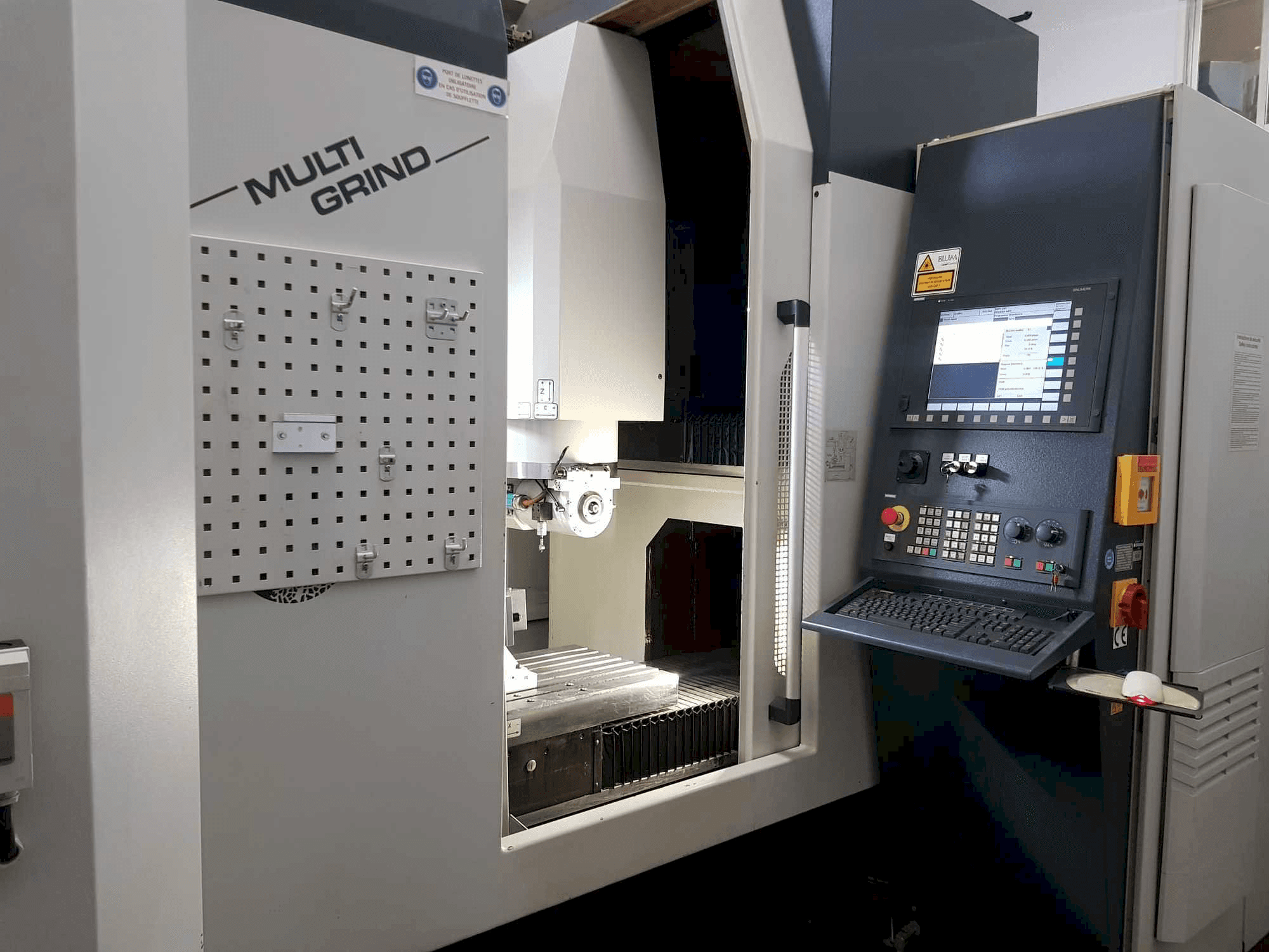 Multi Grind CNC machine with a front view, featuring a control panel, storage pegboard, and an open work area.